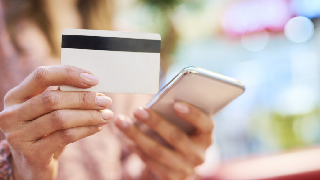 zdjęcie dłonie trzymające kartę kredytową i telefon