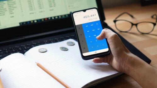zdjęcie przedstawiające telefon, pieniądze i komputer